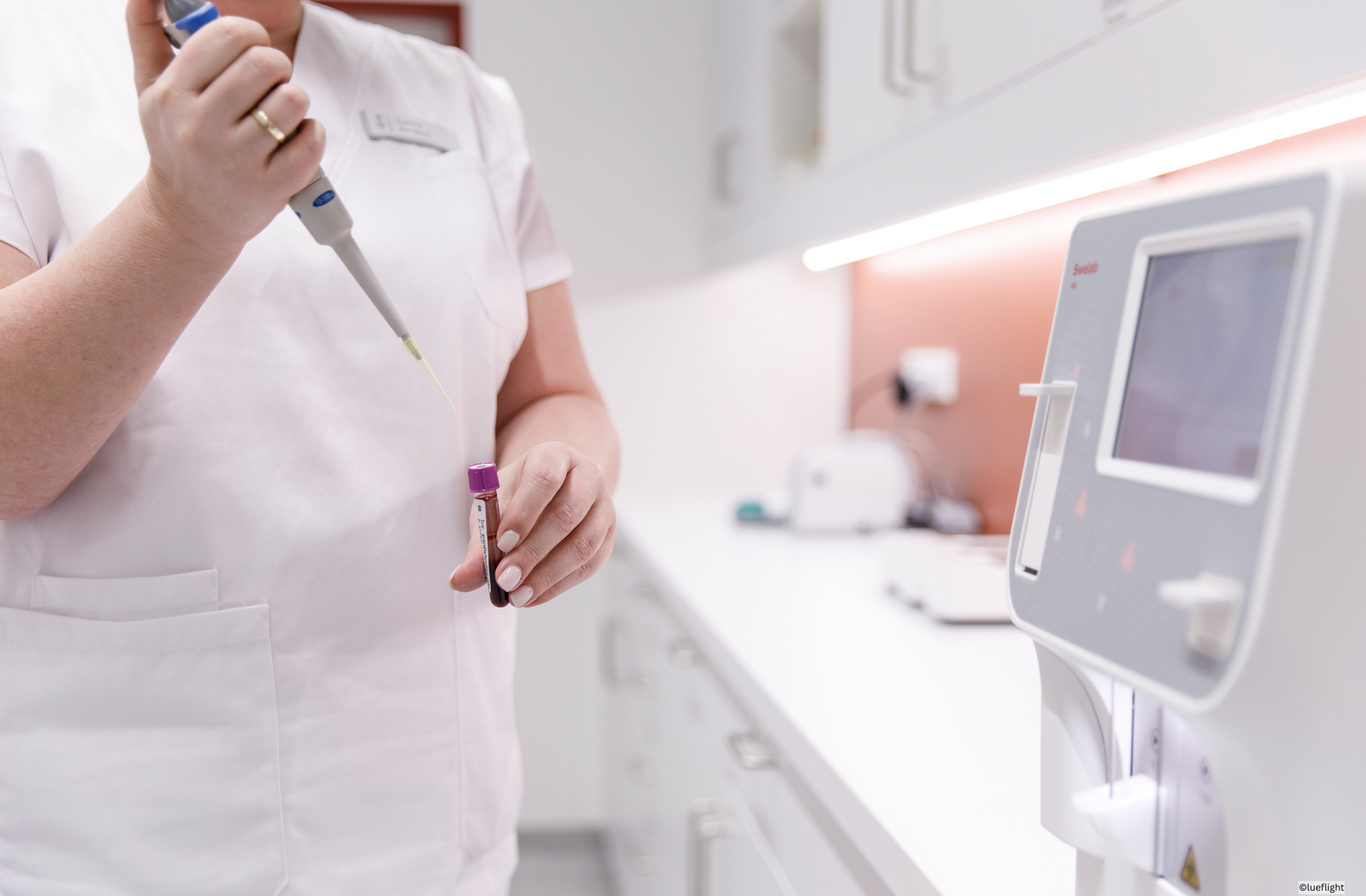 Eine Pflegerin bereitet im Labor etwas vor